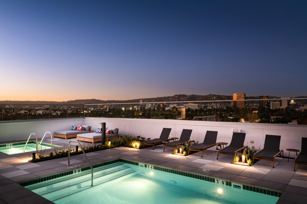 캘리포니아주 로스앤젤레스 미드 시티의 침실 1개 아파트 - 더 파커 - 밤에는 옥상 수영장과 자쿠지 데크, 라운지 의자, 조경 식물 침대, 도시 전망을 즐길 수 있습니다.